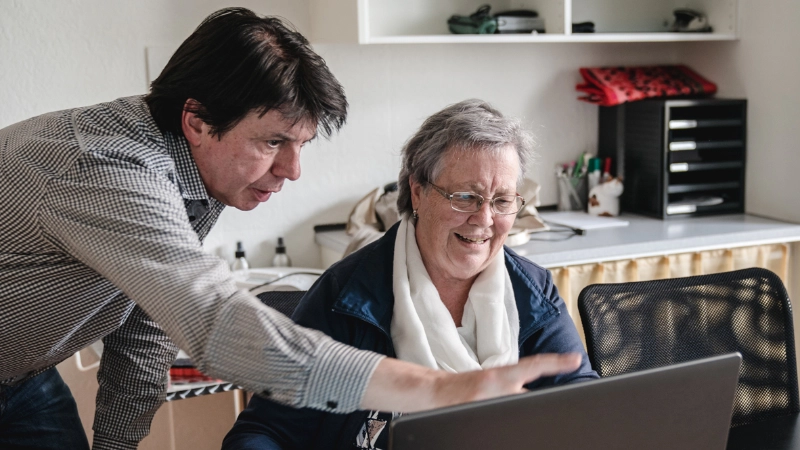 Kursleiter zeigt auf Laptop