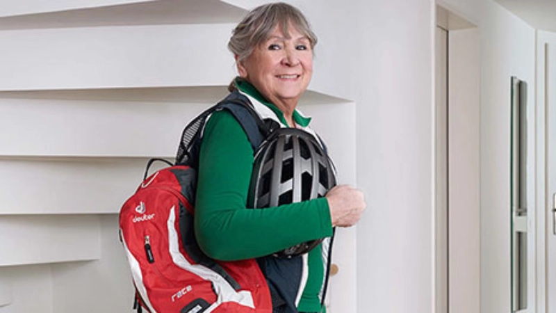 Frau mit Velohelm und Rucksack