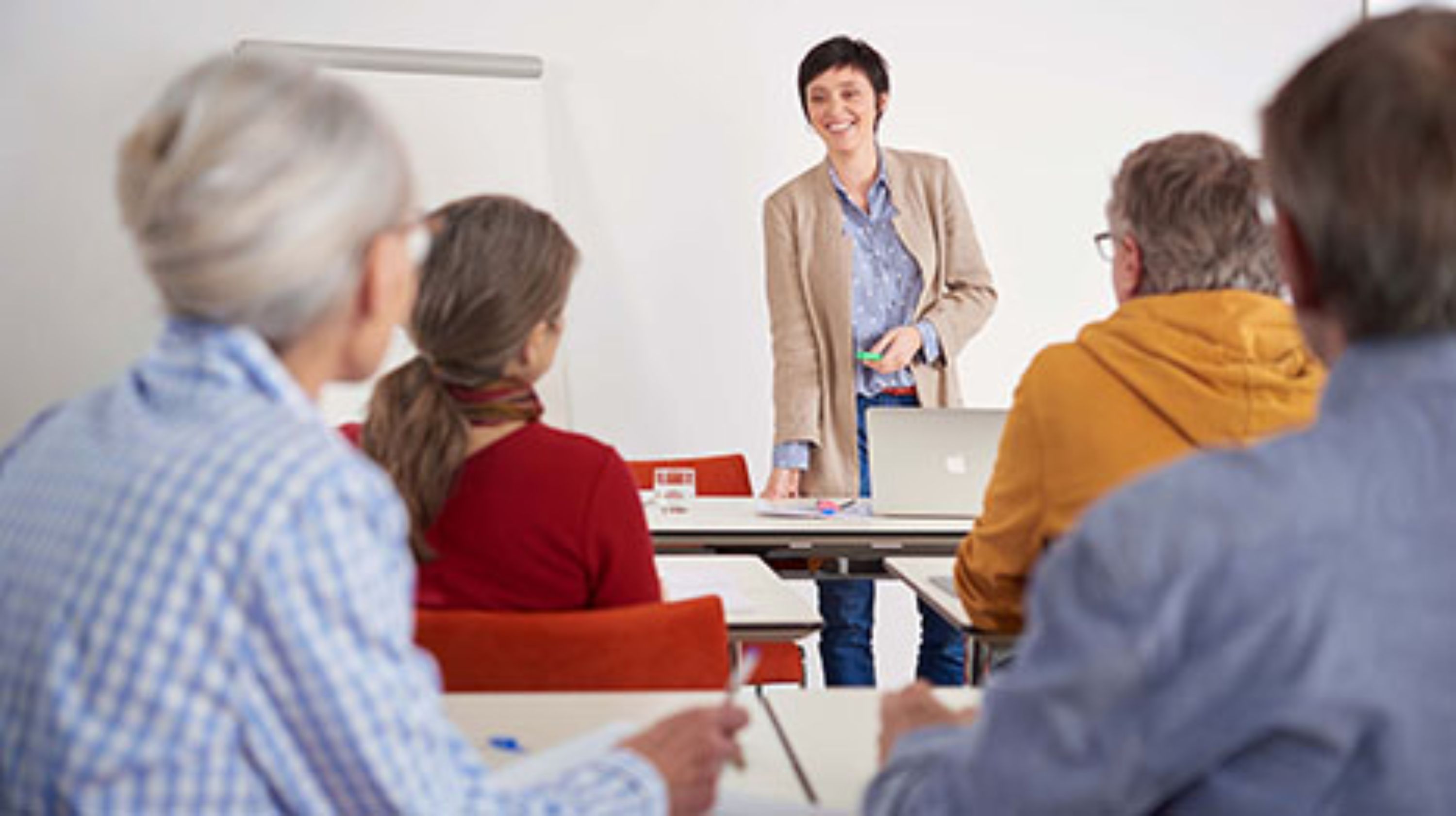 Kursleiterin steht vor Gruppe