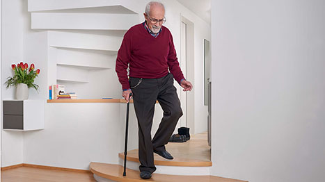 Mann mit Stock geht Treppe runter